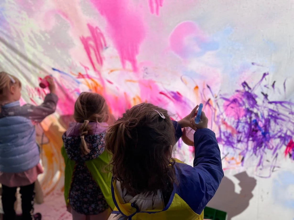 Bambini che sperimentano la pittura su una superficie trasparente